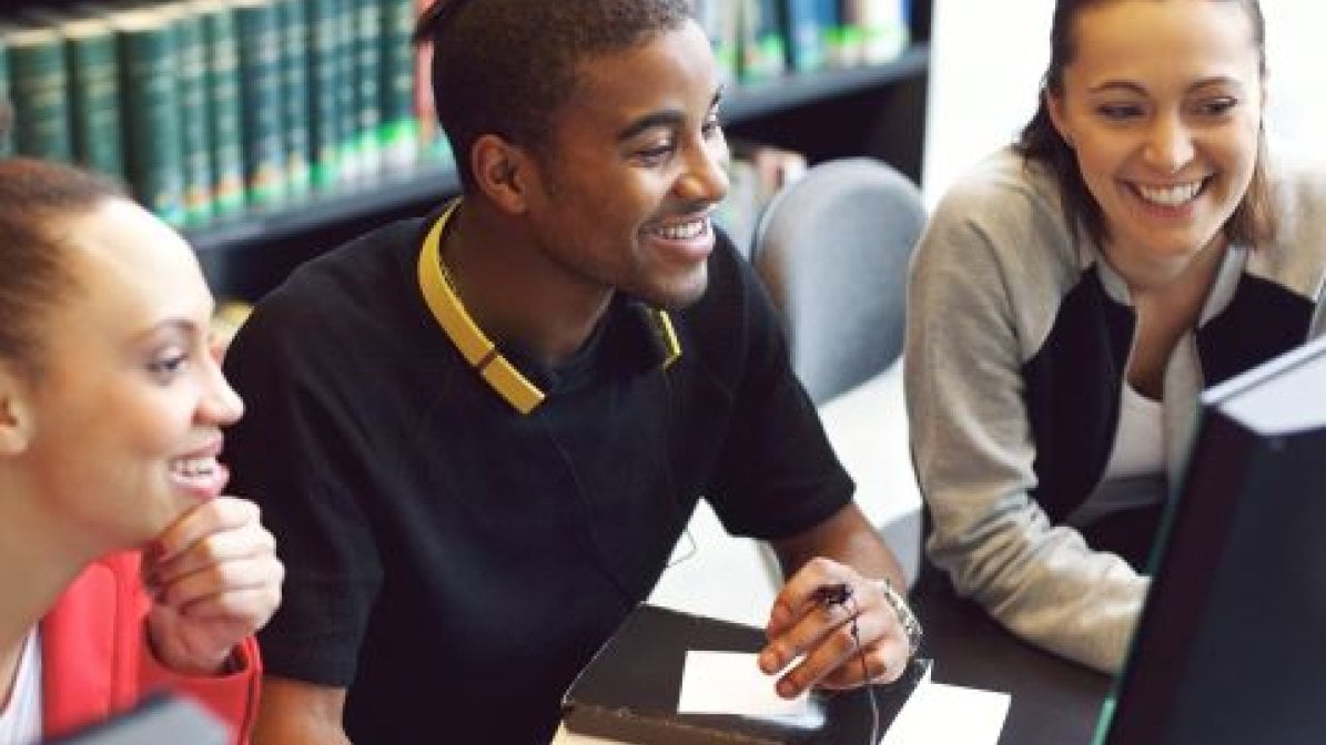 Students looking at computer screen in a library