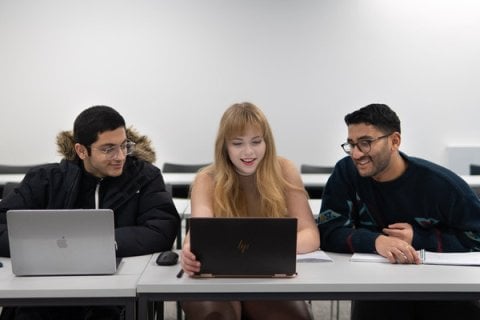 Students writing their personal statements on laptops